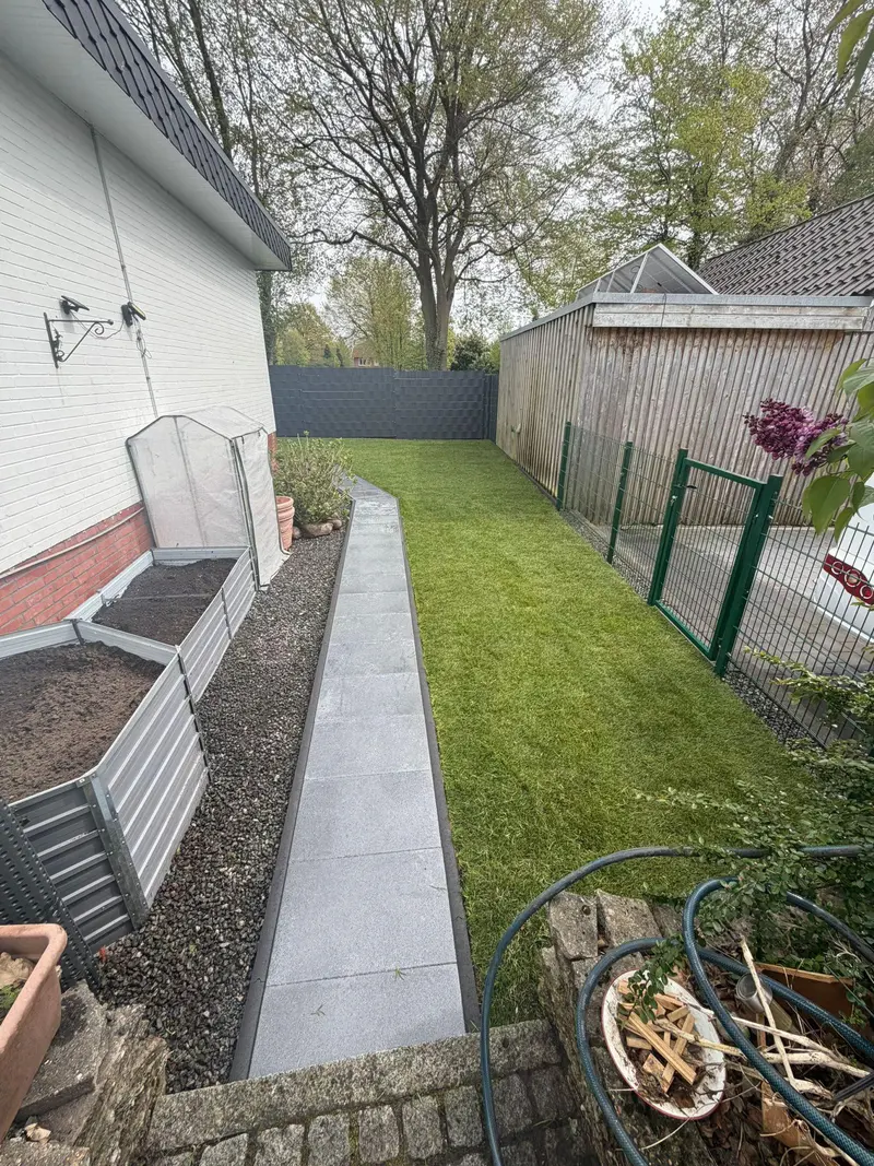 Fertiger Garten mit frisch verlegtem Rollrasen, Plattenweg und neuen Hochbeeten