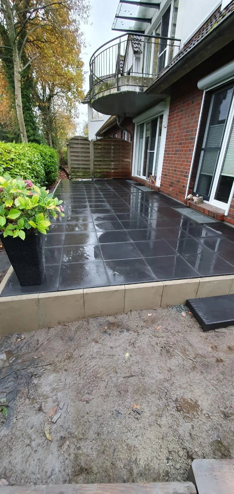Fertige Terrasse aus großformatigen anthrazitfarbenen Platten mit Randeinfassung
